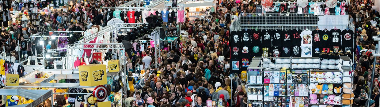 Shot of a hall at the Manga Comic Con with numerous booths and attendees.
