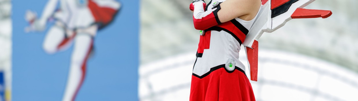 MaCoCo zeigt auf den Wegweiser der Manga-Comic-Con, der auf Halle 1 und 3 verweist.