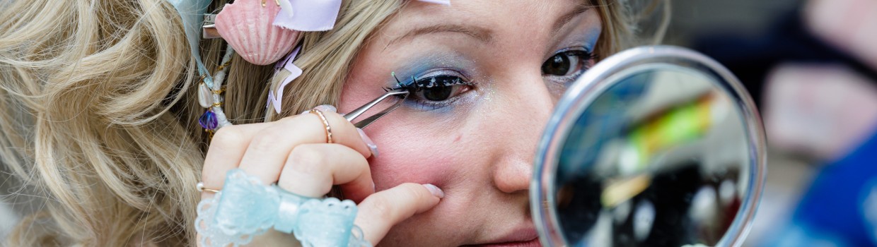 Cosplayer:in schminkt sich auf der Manga-Comic-Con 2024