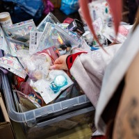 Besucher:int durchsucht Artikel in einer Box am Bring & Buy Stand auf der Manga-Comic-Con 2025