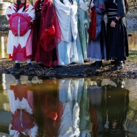 Gruppe von Cosplay:innen posieren im Freien in ihren Kostümen auf der Manga Comic Con 2025, im Wasser sieht man ihr Spiegelbild