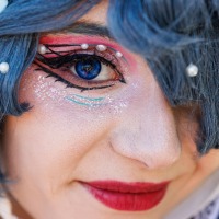 Cosplayer:in mit blauer Perücke und blauen Kontaktlinsen auf der Manga Comic Con 2025