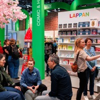 Besucher:innen der Manga Comic Con 2025 an einem Stand mit Büchern und Comics