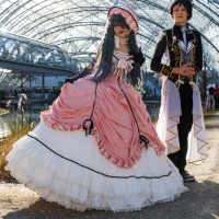 Two cosplayers posing at the Manga Comic Con 2025 in front of the Glass Hall at the Leipzig Trade Fair
