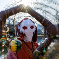 Cosplayer in a red outfit with a white bird mask at the Manga Comic Con 2025
