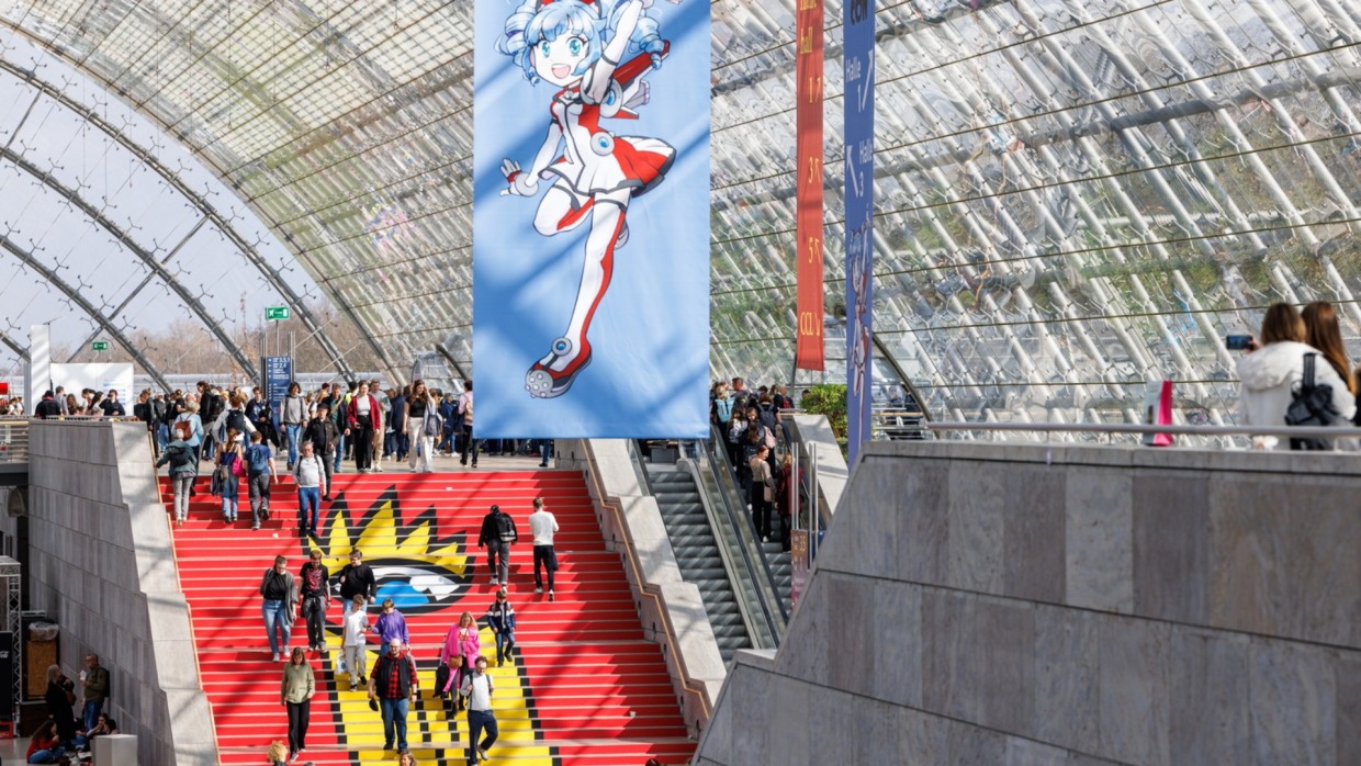 Glashalle mit Banner und roter Treppe während der Manga Comic Con 2025