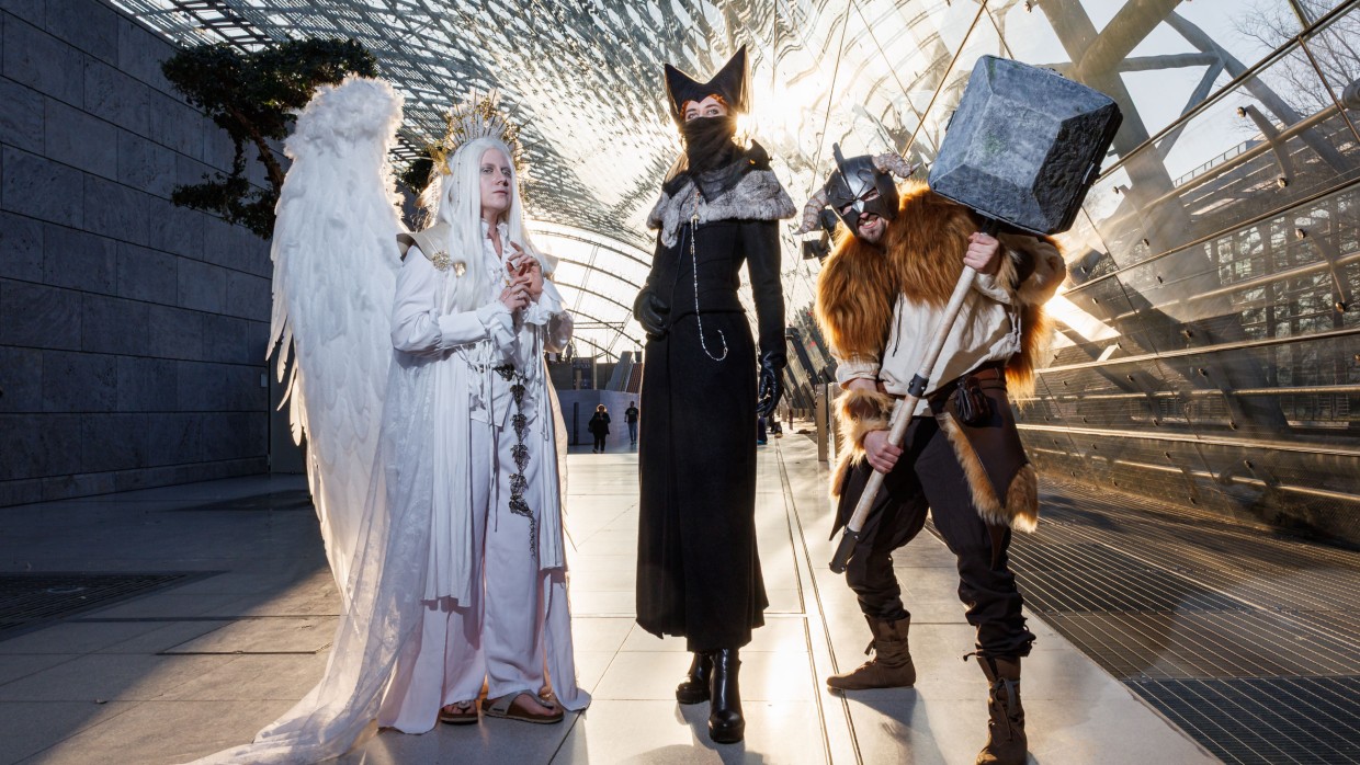 Drei verkleidete Personen auf der Manga-Comic-Con 2025 posieren in der Glashalle der Leipziger Messe
