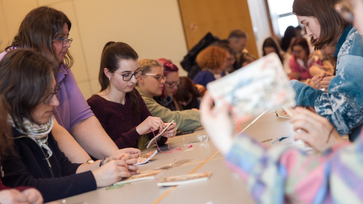 Teilnehmer:innen basteln an einem lange Tisch während eines Workshops auf der Manga Comic Con 2025