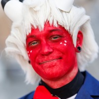Eine Person mit rot geschminktem Gesicht und weißer Perücke auf der Manga-Comic-Con 2025