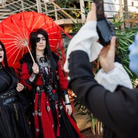 Cosplayer:in macht von 2 anderen Cosplayer:innen ein Foto auf der Manga Comic Con 2025