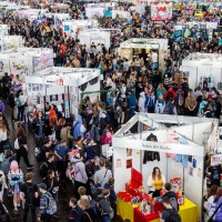 Große Messehalle mit vielen Besucher:innen und zahlreichen Ständen auf der Manga Comic Con 2025