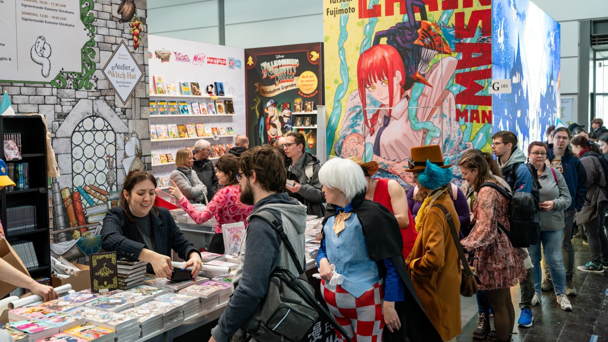 Besucher:innen stehen Schlange an einem Messestand auf der Manga-Comic-Con 2025