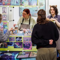 Künstlerstand mit Besucher:innen in der New Artist Alley auf der Manga-Comic-Con 2025