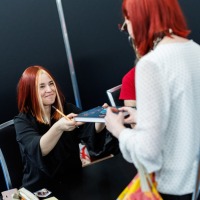 Jenny Jinya überreicht einem Fan ein signiertes Buch auf der Manga-Comic-Con 2025