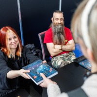 Jenny Jinya überreicht einem Fan ein signiertes Buch auf der Manga-Comic-Con 2025 Jenny Jinya überreicht einem Fan ein signiertes Buch auf der Manga-Comic-Con 2025