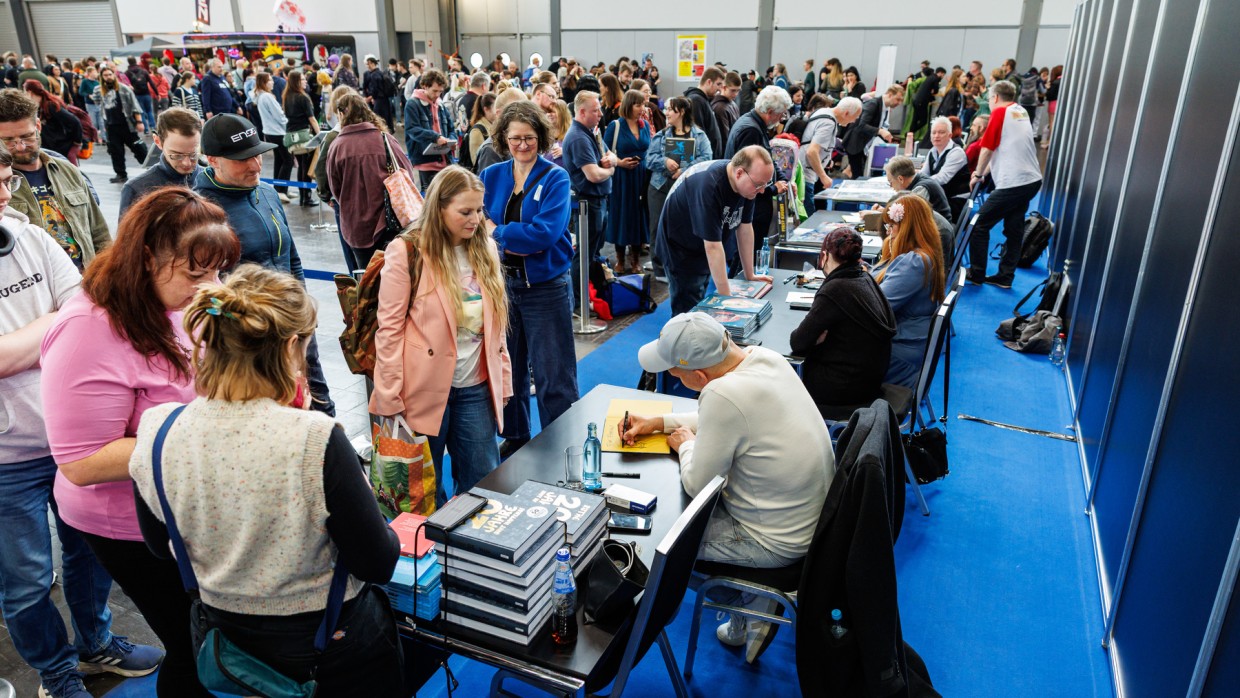 Signierbereich auf der Manga-Comic-Con 2025 mit vielen Besucher:innen, die sich an mehreren Signiertischen von Künstler:innen Autogramme holen