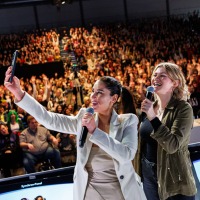 Esra Vural takes a selfie on the Main Stage of the Manga-Comic-Con 2025 in front of a full audience
