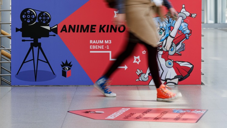 Person läuft an großem Banner des Anime Kinos der Manga Comic Con 2026 vorbei