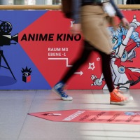 Person läuft an großem Banner des Anime Kinos der Manga Comic Con 2026 vorbei