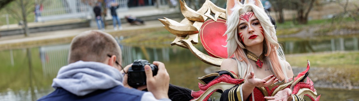 Eine männliche Person in einer Weste mit der Aufschrift "Photography" fotografiert eine Cosplayer:in auf der Manga Comic Con 2026