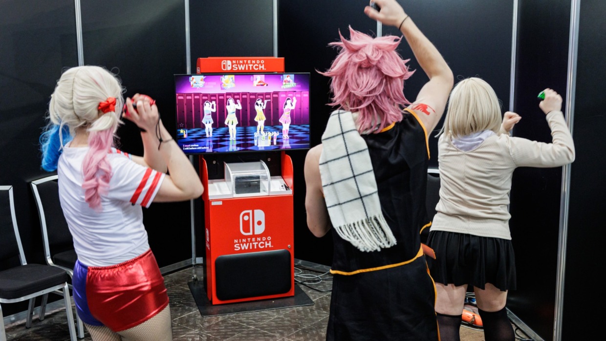 mehrere Personen tanzen an einer Nintendo Switch im Gamesroom der Manga Comic Con 2026