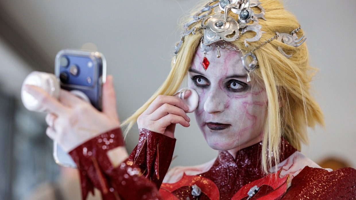 Cosplayer:in schminkt sich auf der Manga Comic Con 2026