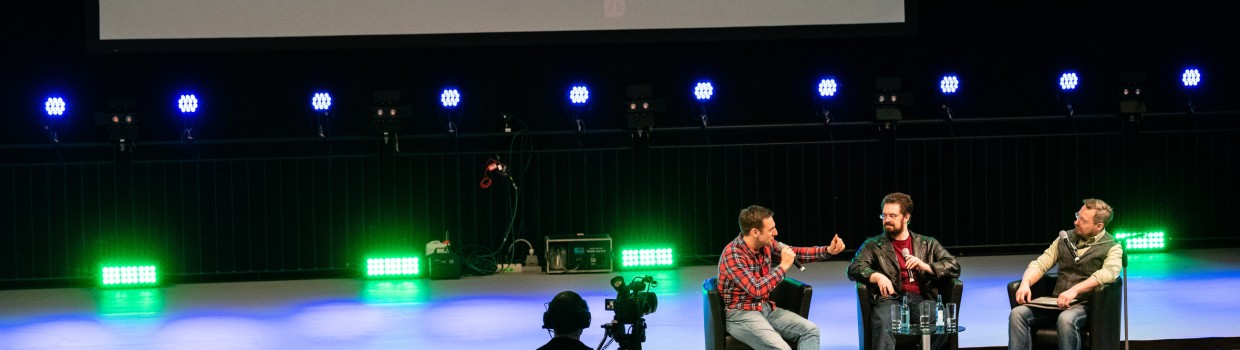 Drei Menschen im Gespräch auf einer Bühne der Leipziger Buchmesse